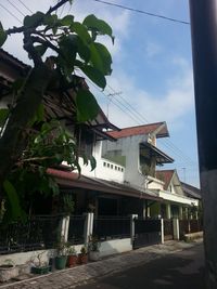 Low angle view of building by street against sky