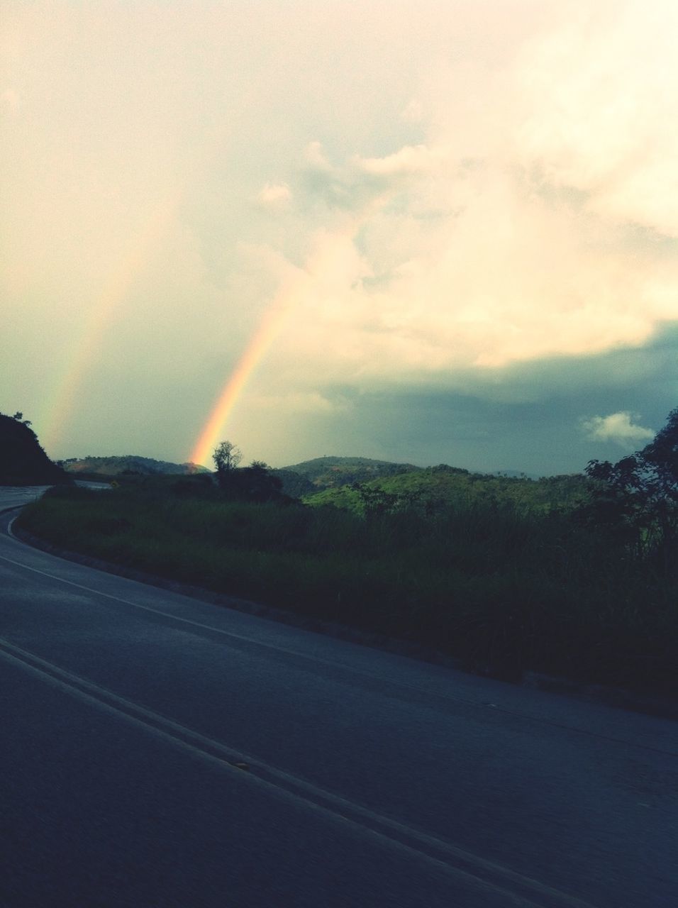 road, sky, transportation, tree, cloud - sky, scenics, rainbow, landscape, beauty in nature, tranquil scene, road marking, tranquility, nature, sunset, street, the way forward, country road, cloud, car, outdoors