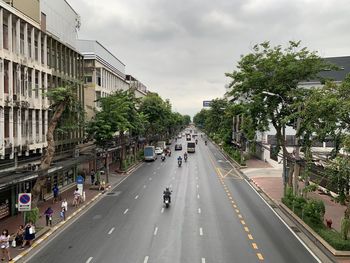 Cars on road against sky in city