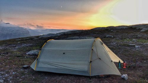 Tent on field against sky during sunset