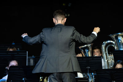 Rear view of man standing at music concert