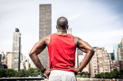 Rear view of man standing against buildings in city