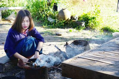 Full length of young woman sitting outdoors