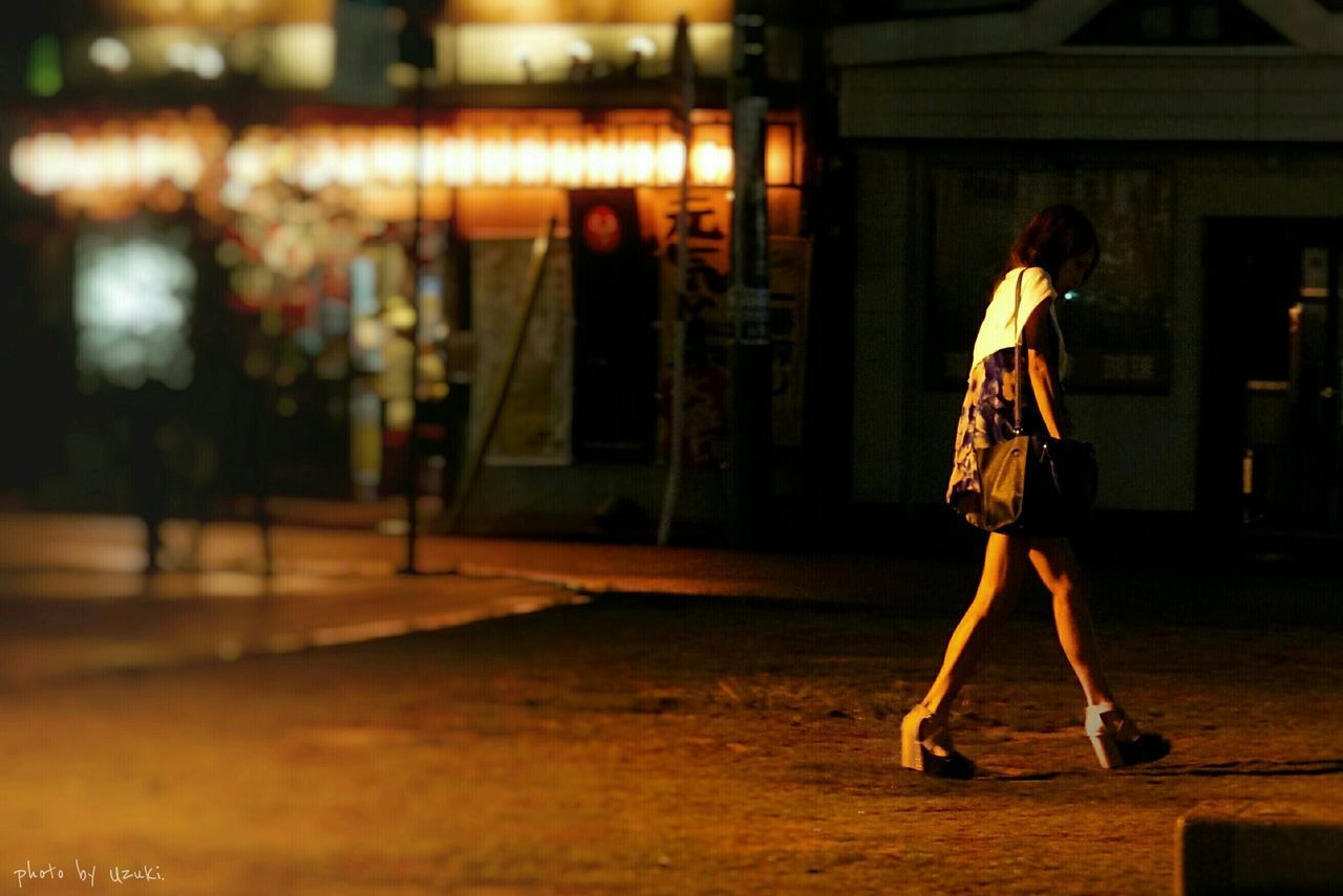 WOMAN STANDING AT NIGHT