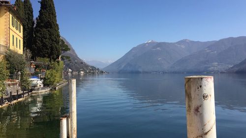 Scenic view of lake and mountains against clear blue sky