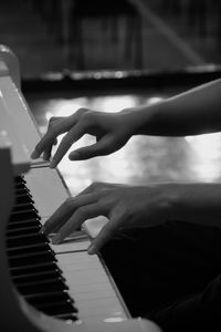 Cropped hands of woman playing piano