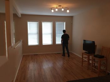 Rear view of man photographing at home
