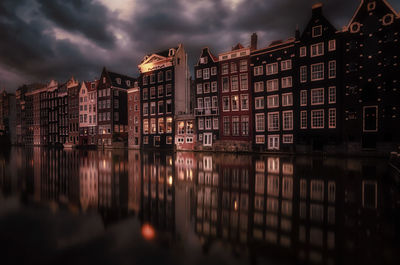 Reflection of buildings on river at sunset