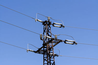 Low angle view of electricity pylon against clear sky