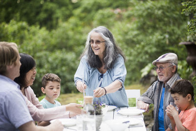 Multi-generational family at table in back yard