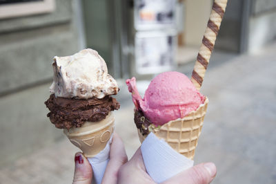 Cropped hands holding ice cream cones