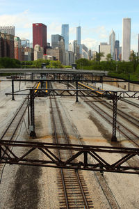 Railroad tracks in city against sky