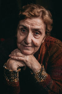 Portrait of senior woman against black background