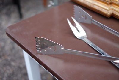 High angle view of serving tongs on table