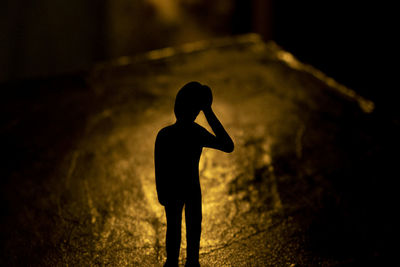 Silhouette man standing on street at night