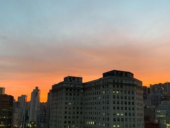 Buildings in city at sunset