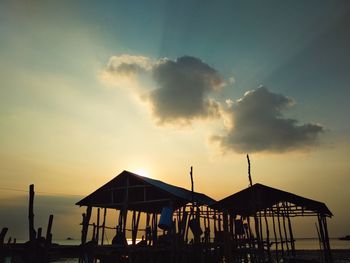 Silhouette people on beach against sky during sunset