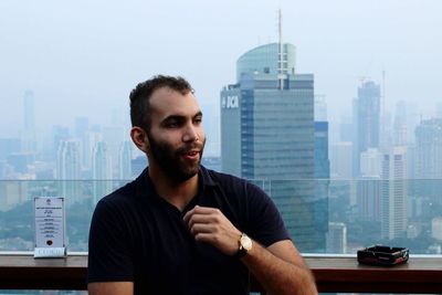 Man looking at modern buildings in city