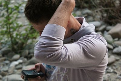 Man using mobile phone with hand in hair