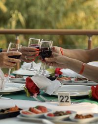 Close-up of hand holding wine glasses on table