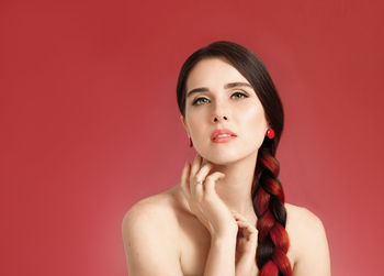 Portrait of young woman against yellow background