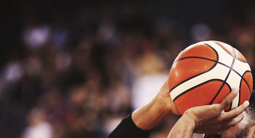 Close-up of hand holding ball against blurred background