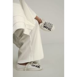 Low section of person wearing shoes against white background