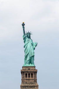 Low angle view of statue of liberty against sky