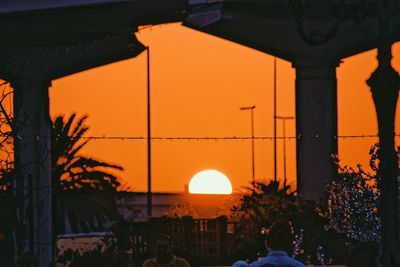 People on illuminated street during sunset