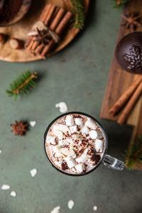 Hot chocolate with marshmallow and cocoa bomb. winter composition with fir branches and spices.
