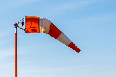 Low angle view of red flag against clear sky