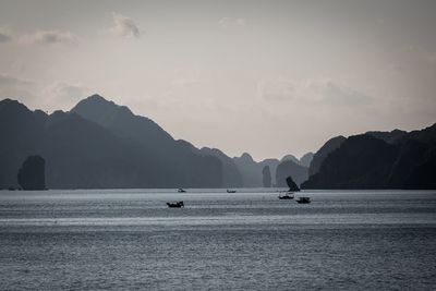 Scenic view of sea and mountains against sky