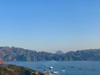 Sailboats in sea against clear sky