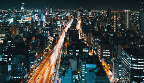 High angle view of illuminated city street and buildings at night