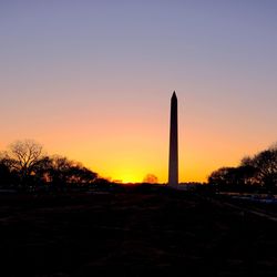 Silhouette trees against clear sky during sunset