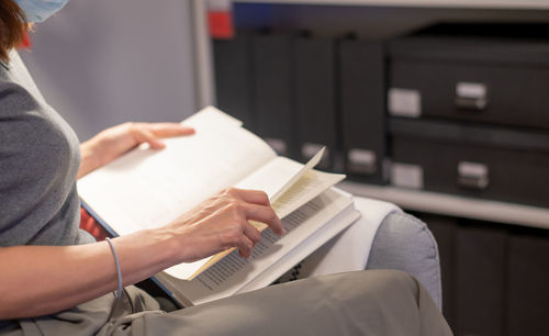 Midsection of woman reading book