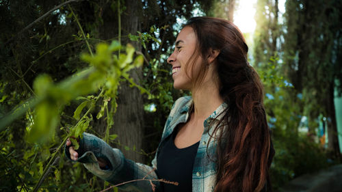 Young woman smiling while standing at park