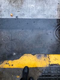 Low section of person standing on yellow metal