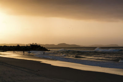 Scenic view of beach against sky during sunset