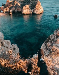 Low section of person on rock by sea