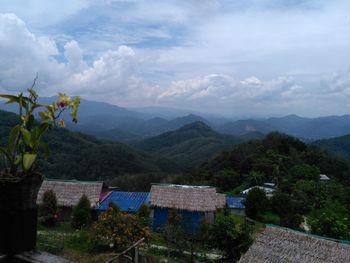 Houses by mountains against sky