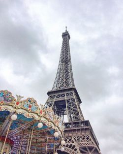 Low angle view of eiffel tower against cloudy sky