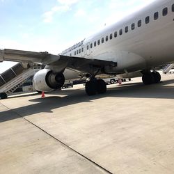 Airplane on airport runway against sky