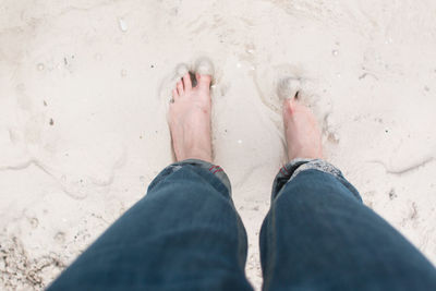 Low section of person standing on wet shore