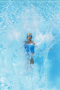 Woman swimming in clear blue swimming pool