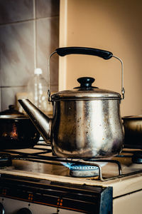 Close-up of kettle heating on burner in kitchen at home