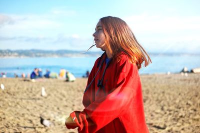 Girl walking at beach against sky