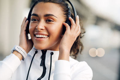 Smiling young woman looking away while listening music