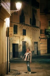 Side view of young woman using mobile phone while standing in abandoned building