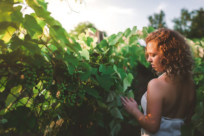 Midsection of woman standing by plants